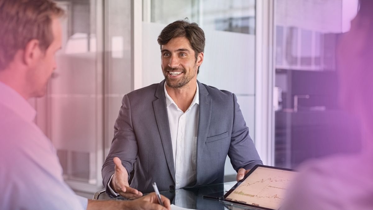 An immigration consultant going through a file with clients across a desk