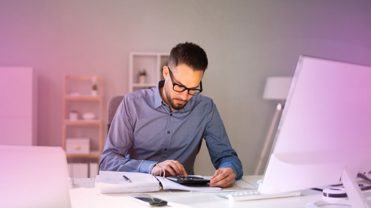 An accountant working through figures on a calculator at a desk
